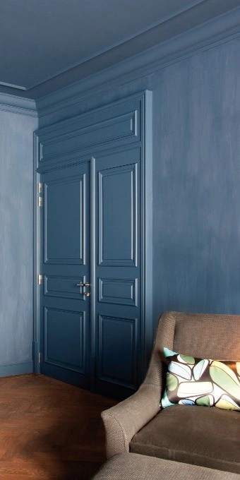 Orac C901 panel moulding in a room corner with modern blue door and sofa