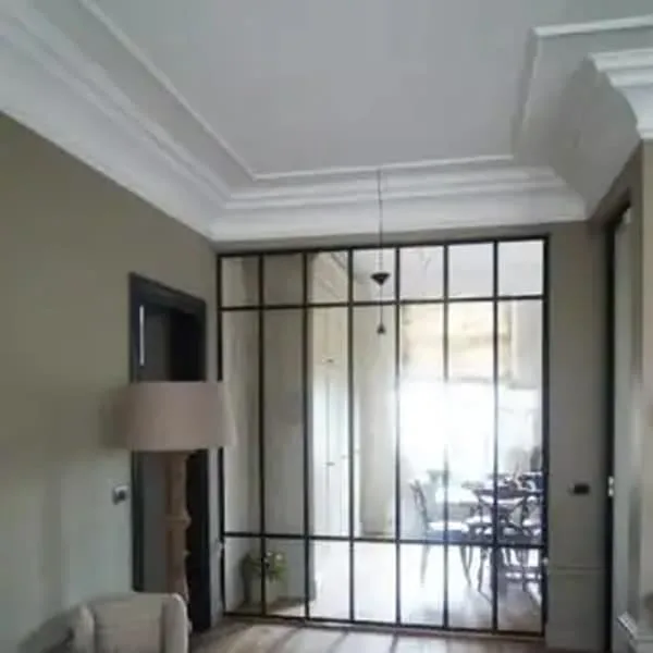 Orac PX120 panel moulding in a modern living room corner with glass partition and minimalist decor