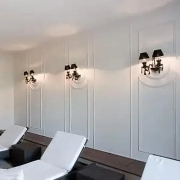 Orac R08 2 panel moulding in a modern minimalist interior with white lounge chairs and black wall sconces