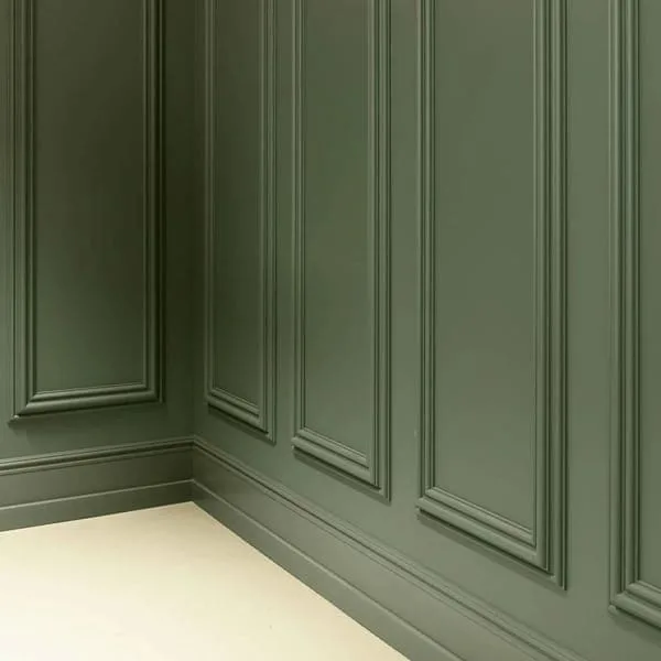 Orac SX118 skirting in a room corner with green panelled wall and beige floor