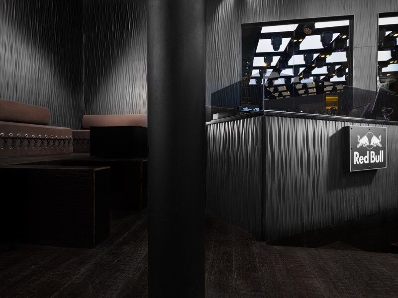 NMC 02 000008 Coving fitted in a room corner with textured walls, modern dark lounge setting and Red Bull DJ booth