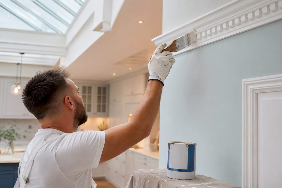 Painter applying finish on polyurethane dentil moulding