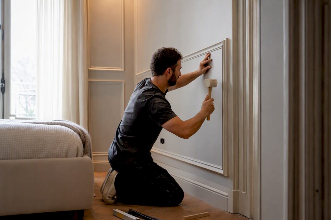 Professional installer fitting wall panels in bedroom