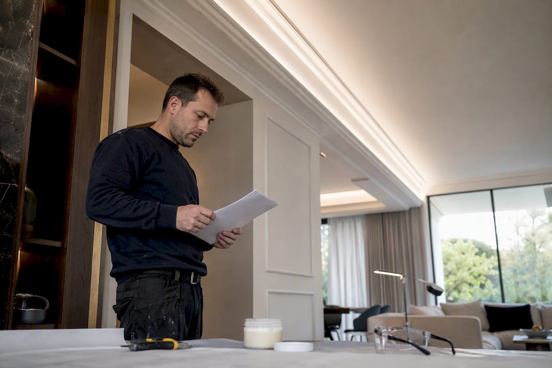 Installer reviewing technical paperwork beside installed coving